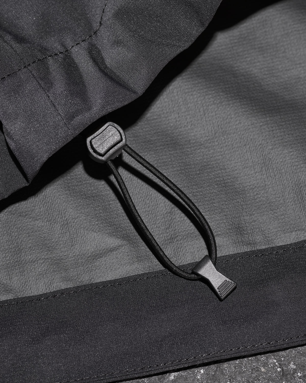 Close-up of packable windbreaker fabric and zipper details on STRAUSS women's e.s.trail light pack windbreaker in black