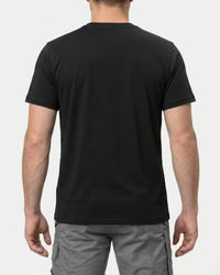 A model wears the STRAUSS Cotton T-Shirt in black with tan work pants and work boots, showing the shirt fit
