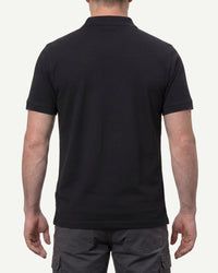 A model wears the STRAUSS Cotton Polo Shirt in black with tan work pants and work boots, showing the shirt fit