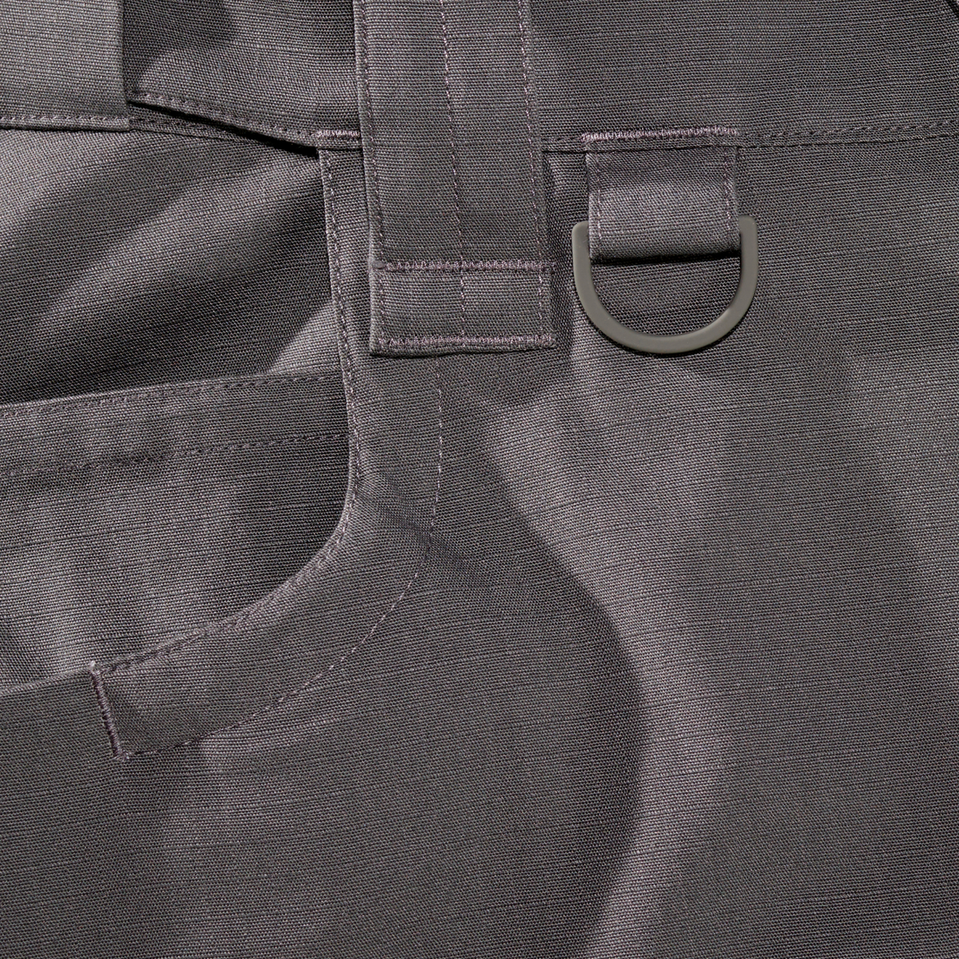 Close-up of a gray ripstop pants with a D-ring buckle.