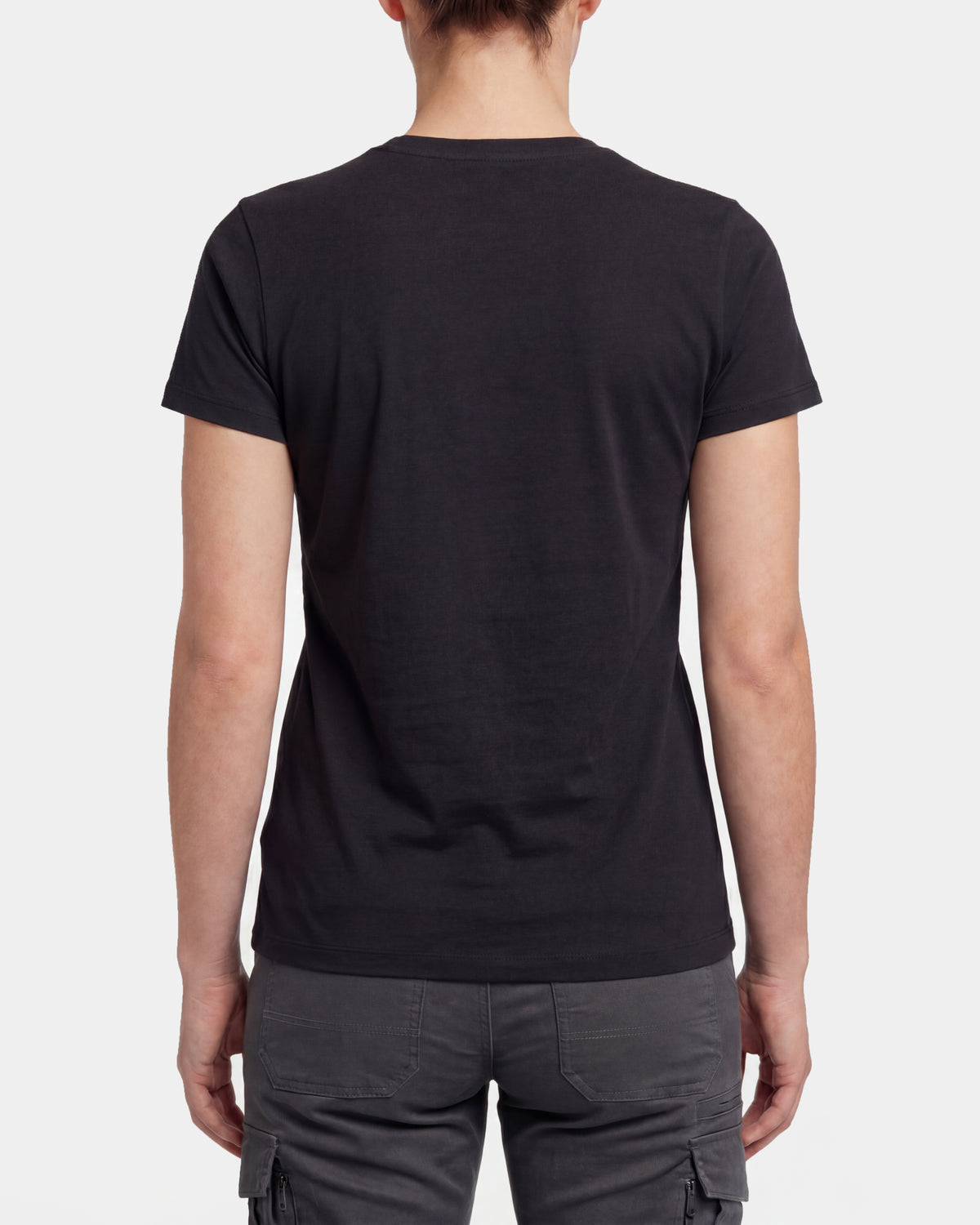 A woman wears the Women's STRAUSS T-Shirt e.s.concrete in black with work pants and work boots, showing the shirt fit