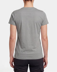 A woman wears the Women's STRAUSS T-Shirt e.s.concrete in pearl gray with work pants and work boots, showing the shirt fit