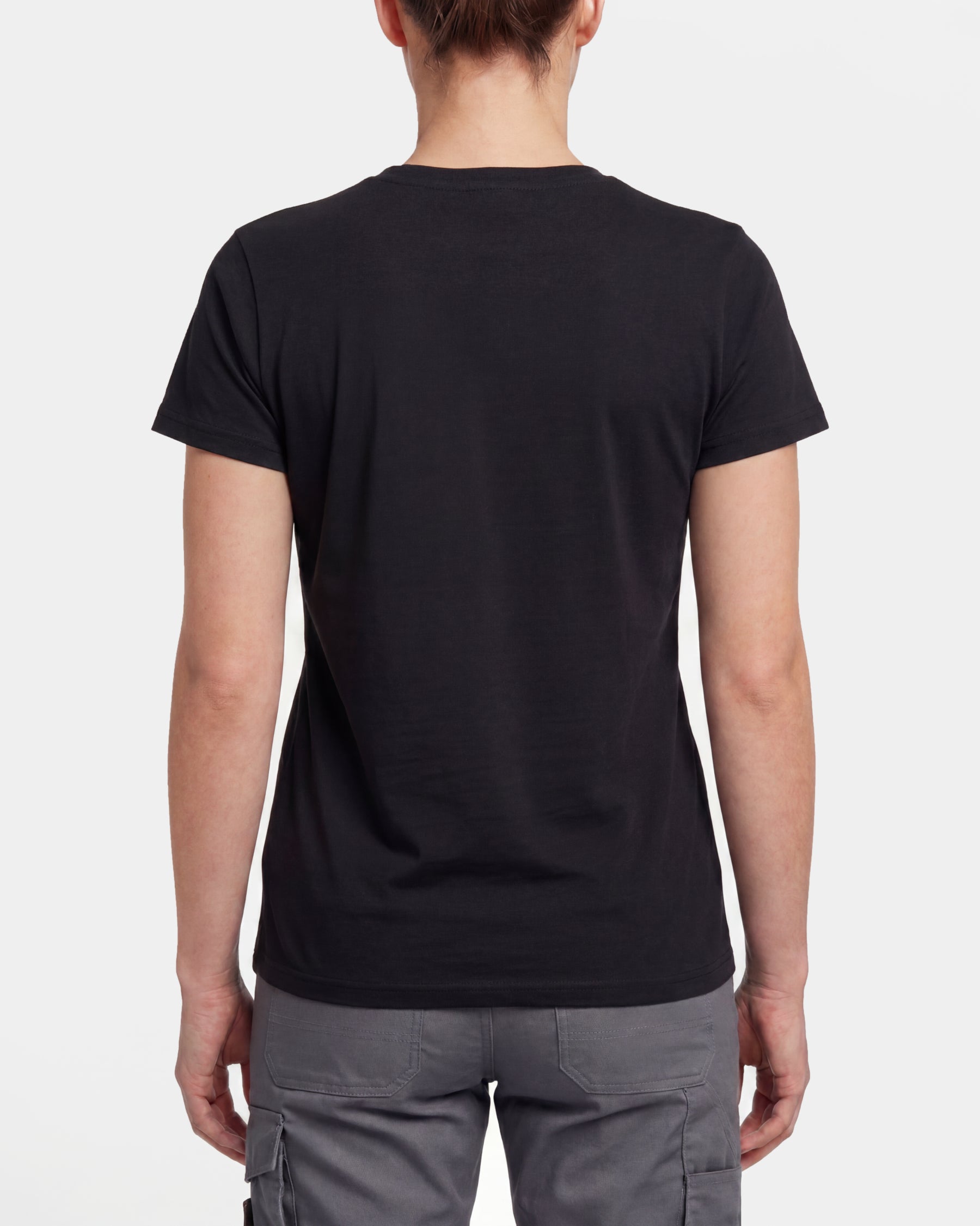 A woman wears the Women's STRAUSS Artwork T-Shirt e.s.e:pic in black with work pants and work boots, showing the shirt fit