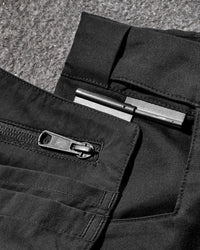 Close-up detail of Engelbert Strauss women's e.s. concrete light shorts in black, focusing on the utility pocket area, seams, and reinforced workwear construction.