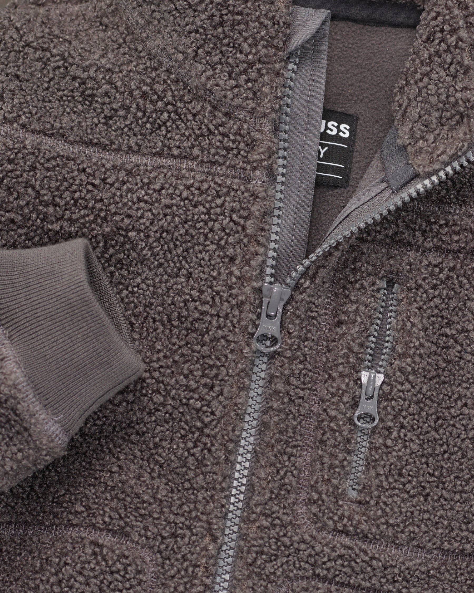 Close-up of sherpa fleece texture and collar details on STRAUSS kids' e.s.e:pic sherpa fleece jacket in carbon gray