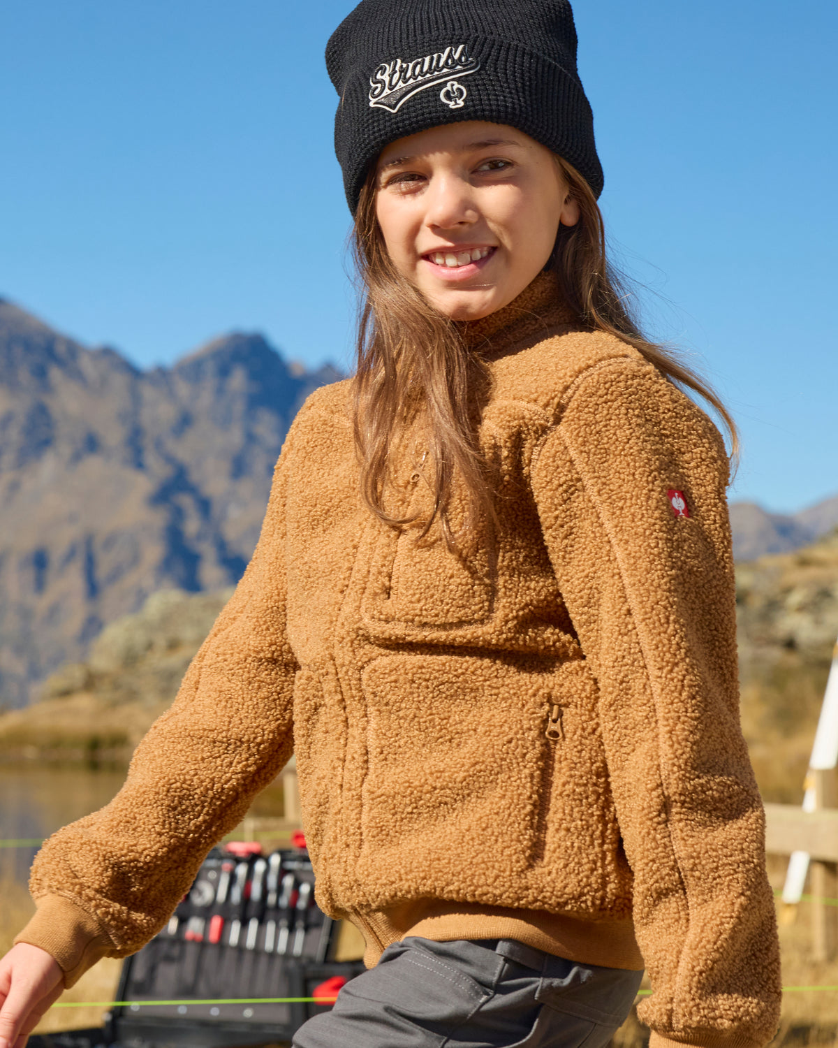 STRAUSS kids' e.s.e:pic sherpa fleece jacket in almond brown shown during outdoor work