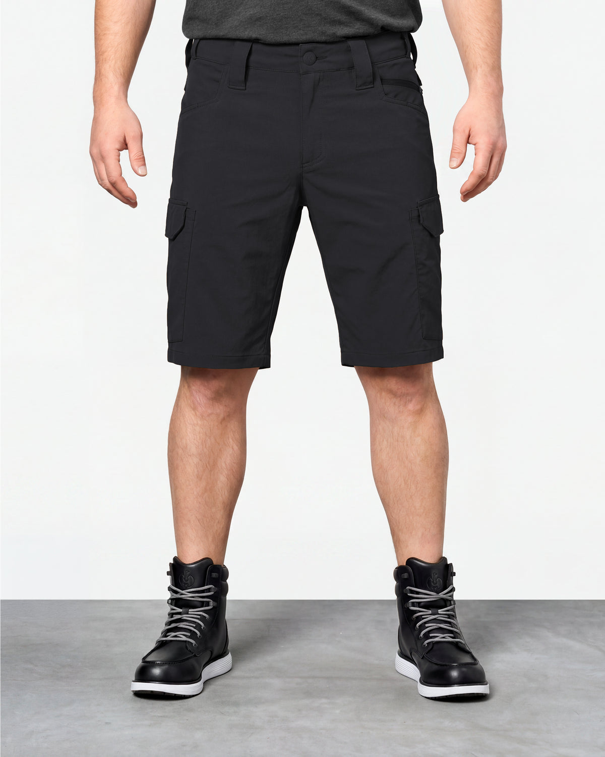 Model wearing Engelbert Strauss e.s. taktik stretch ripstop cargo work shorts in black, showing the fit, length, waistband, and front pocket layout of the durable stretch ripstop cargo work shorts with utility pockets.