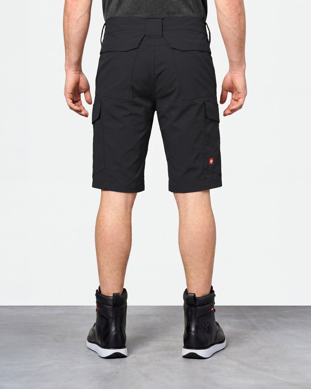 Alternate model view of Engelbert Strauss e.s. taktik stretch ripstop cargo work shorts in black, showing the side and back fit with visible utility pocket placement and workwear construction.