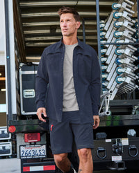 Engelbert Strauss e.s. taktik stretch ripstop cargo work shorts in nero blue in an outdoor-style lifestyle view, showing the shorts as part of a functional work outfit.