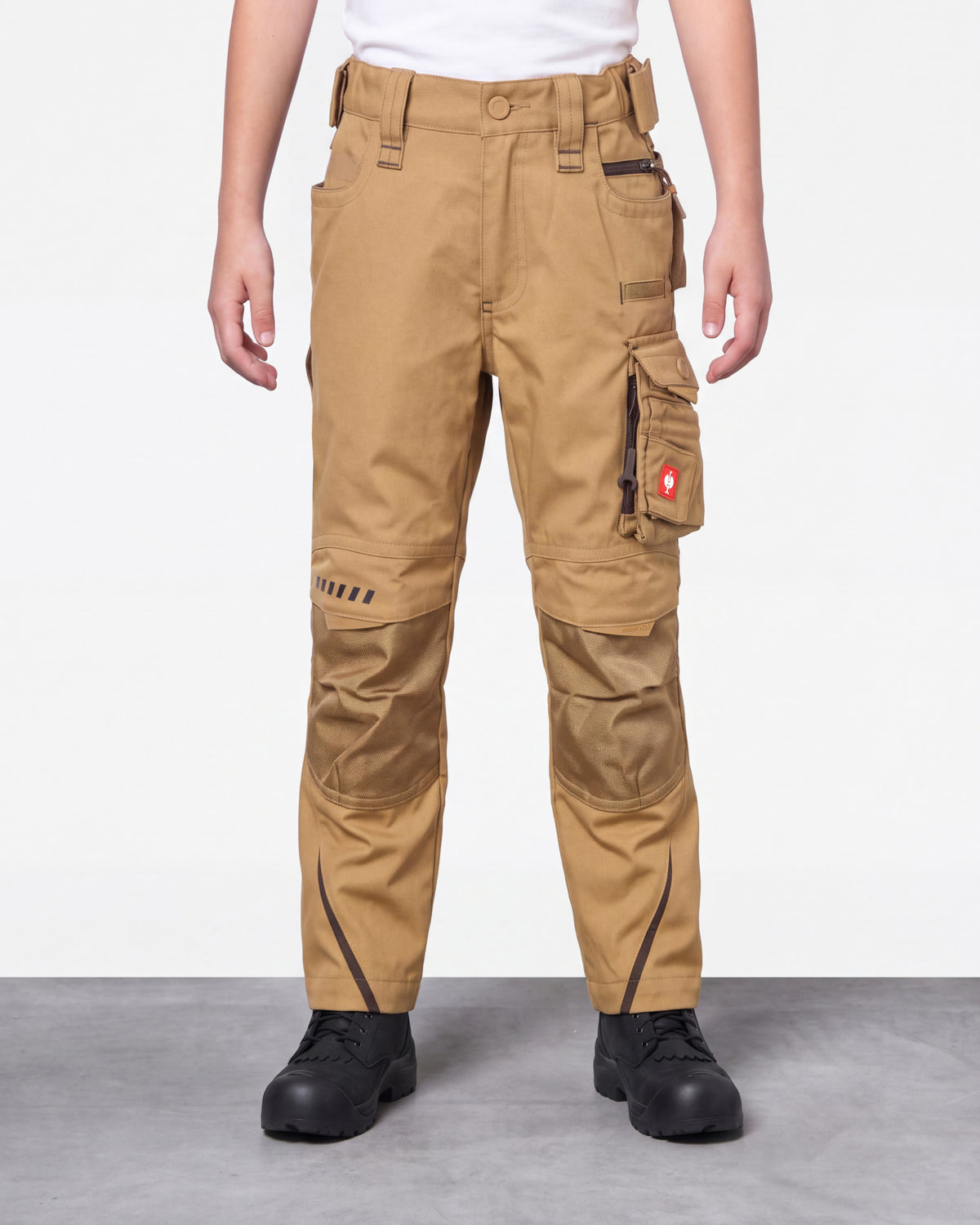 A person wearing tan cargo work pants with black work boots, shown from the waist down against a light gray studio background.