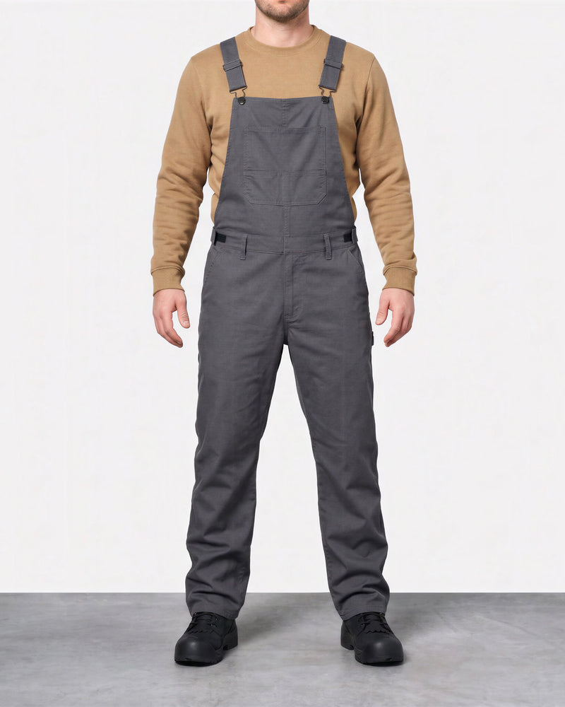 Front view of a model wearing carbon gray STRAUSS stretch canvas bib overalls.