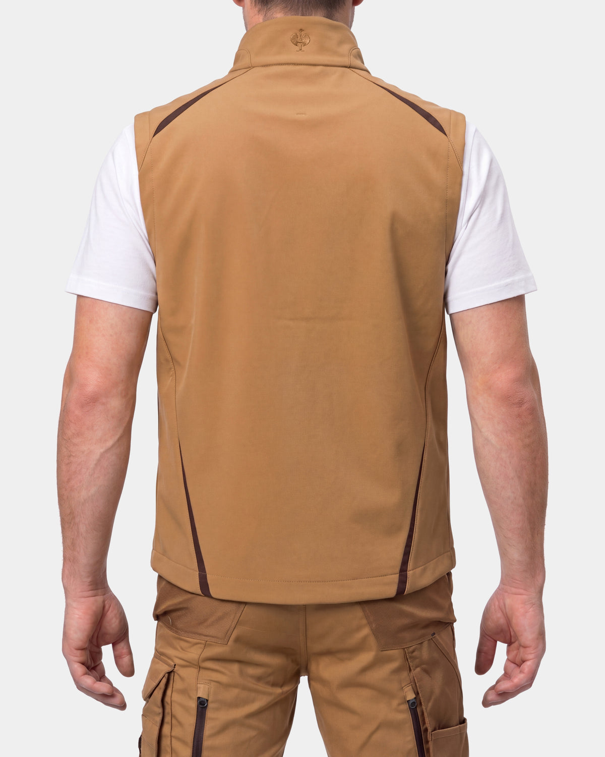 A man shown from the back wearing a tan sleeveless zip-front vest over a white t-shirt and tan cargo pants, against a light gray studio background.