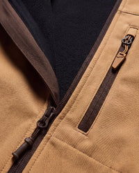 Close-up of a tan fleece-lined zippered jacket showing the tan exterior fabric, dark brown zipper trim, and a black fleece interior.