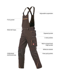 Dark brown technical work overalls with multiple labeled feature callouts, including adjustable suspenders, front pocket, wide belt loops, zippered pocket, side pockets, thigh pocket, knee pad pockets, reflective details, and CORDURA reinforced knee, shown on a white background.