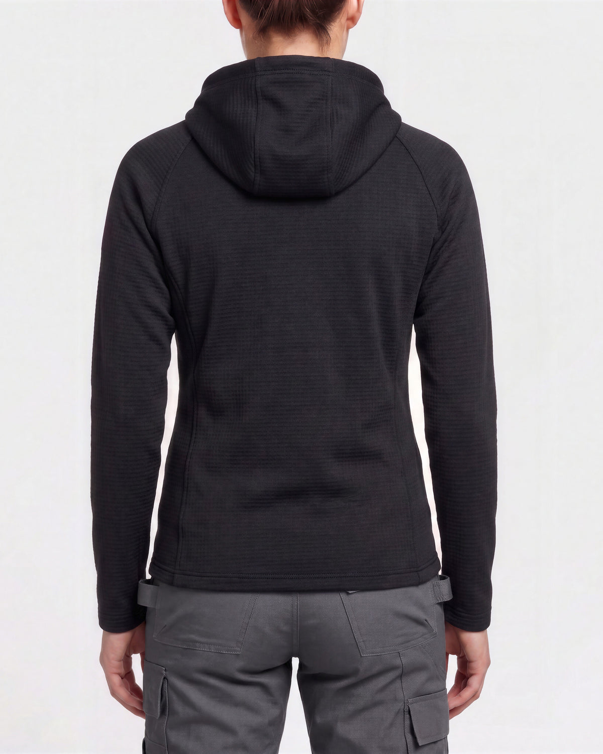 Rear view of a person wearing a dark charcoal hooded long-sleeve top and gray cargo pants against a light gray studio background.