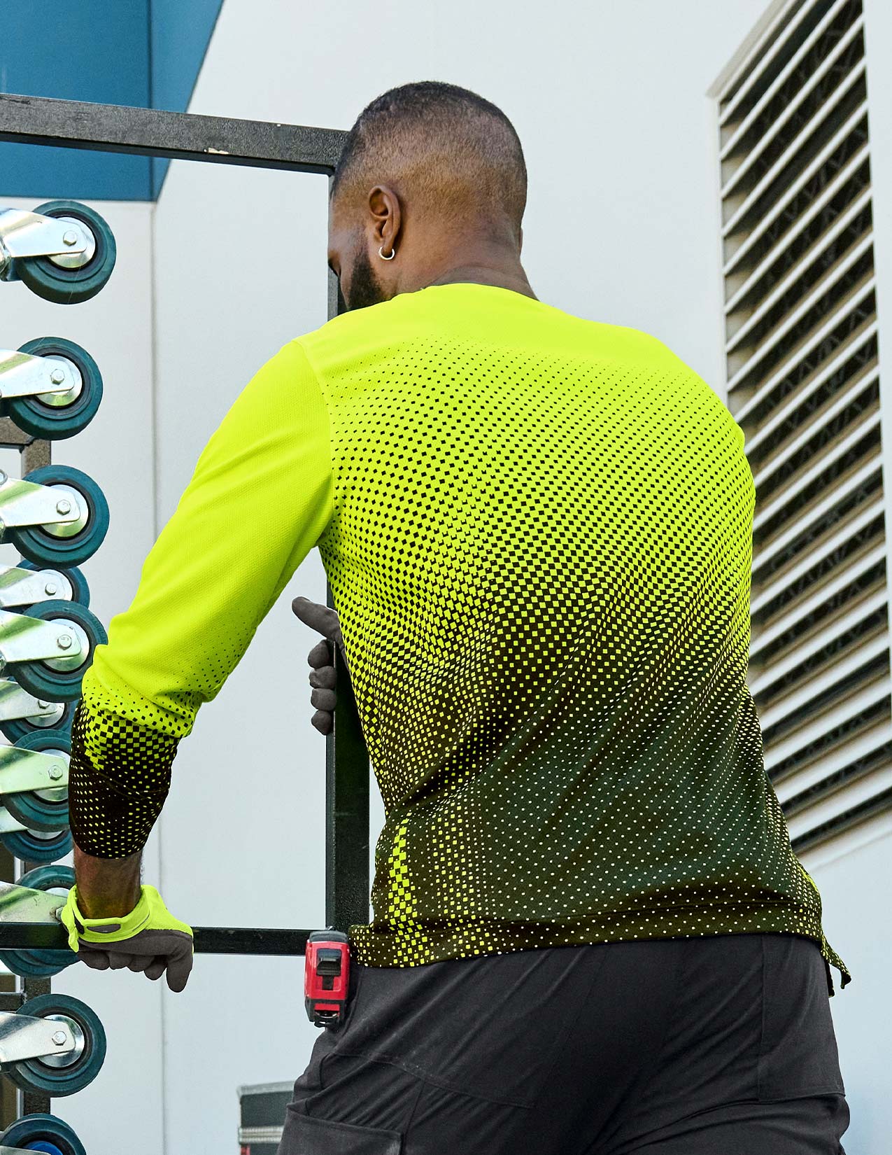 Person wearing a bright yellow athletic shirt with black patterns.