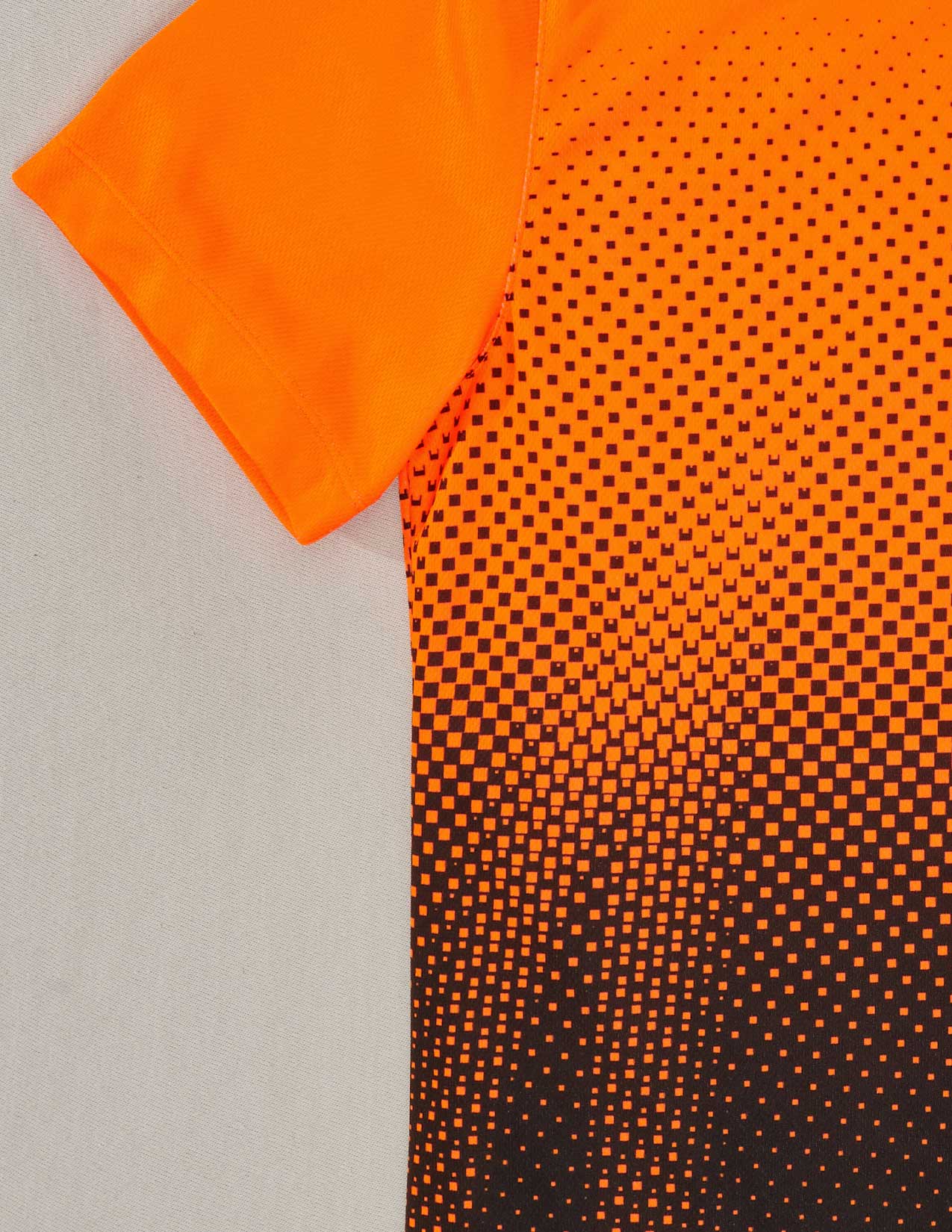 Close-up of an orange and black patterned fabric on a gray background