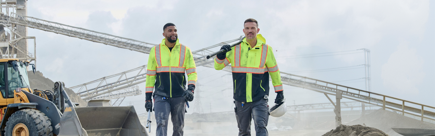 two men walking on a construction site wearing high-vis workwear