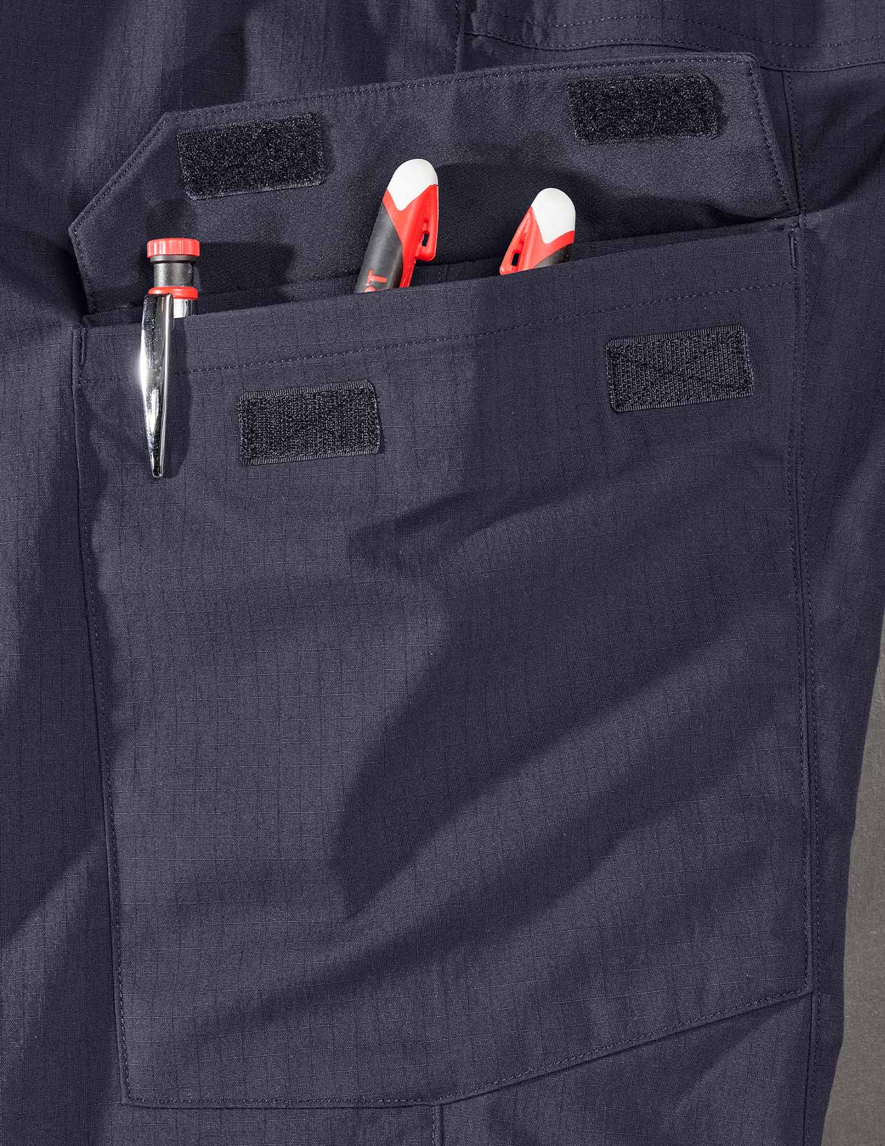 Close-up of dark blue pants with tools in a pocket