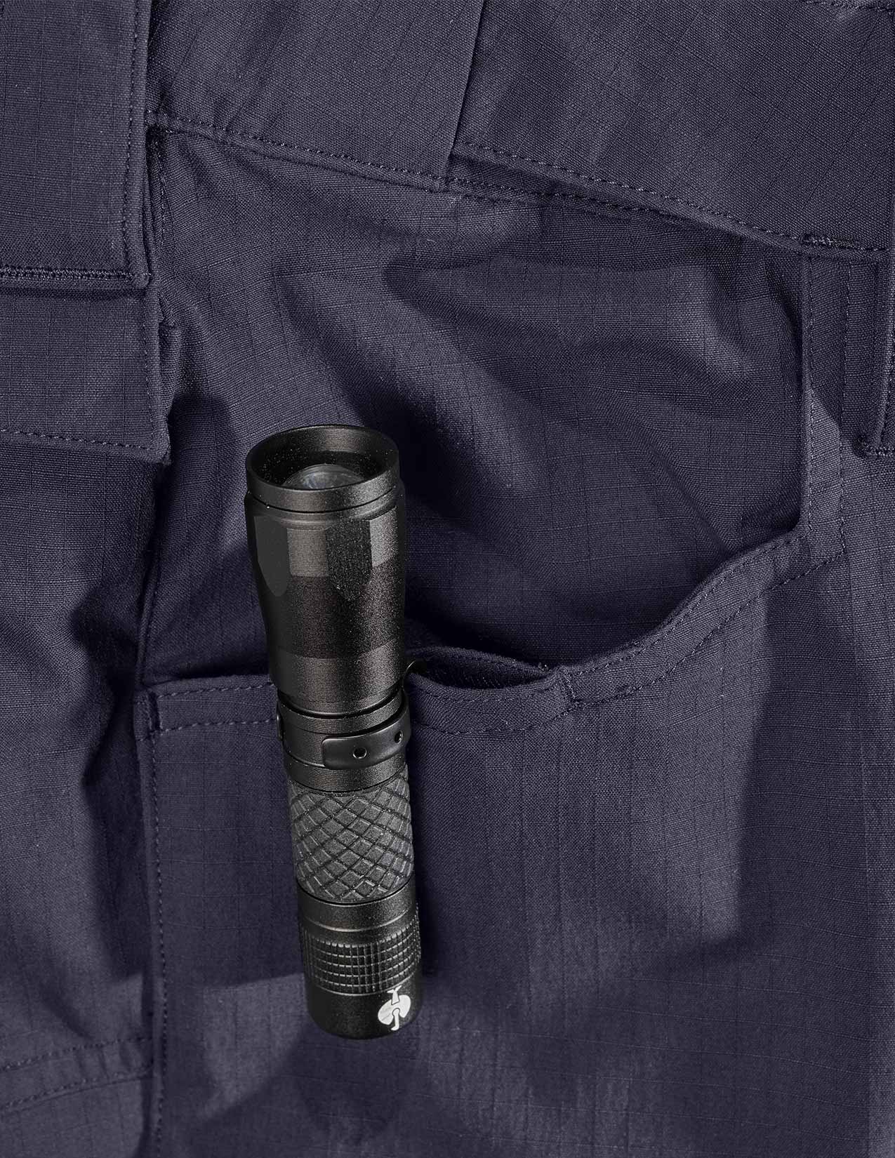 Black flashlight in a pocket of dark blue pants