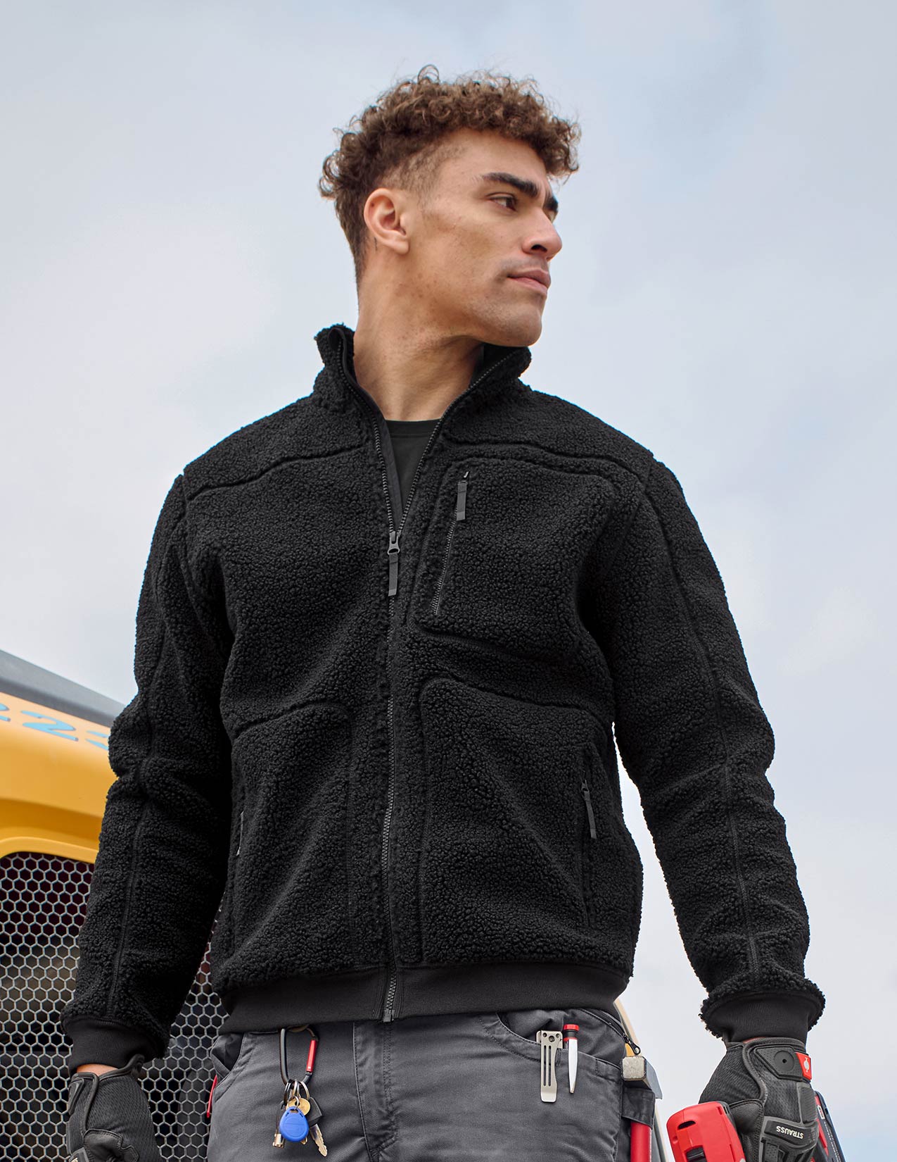 Person wearing a black fleece jacket with a blurred background