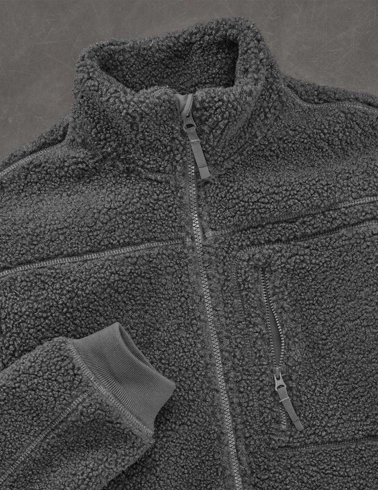 Close-up of a gray fleece jacket with a zipper on a gray background