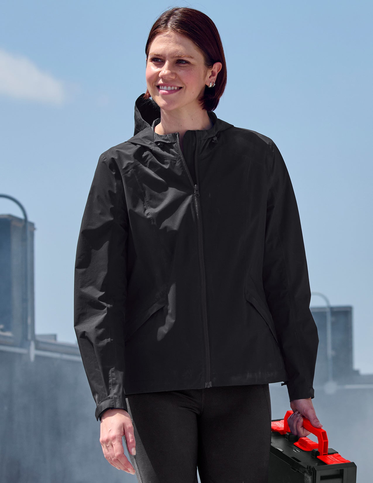 Woman wearing a black jacket with a clear blue sky background