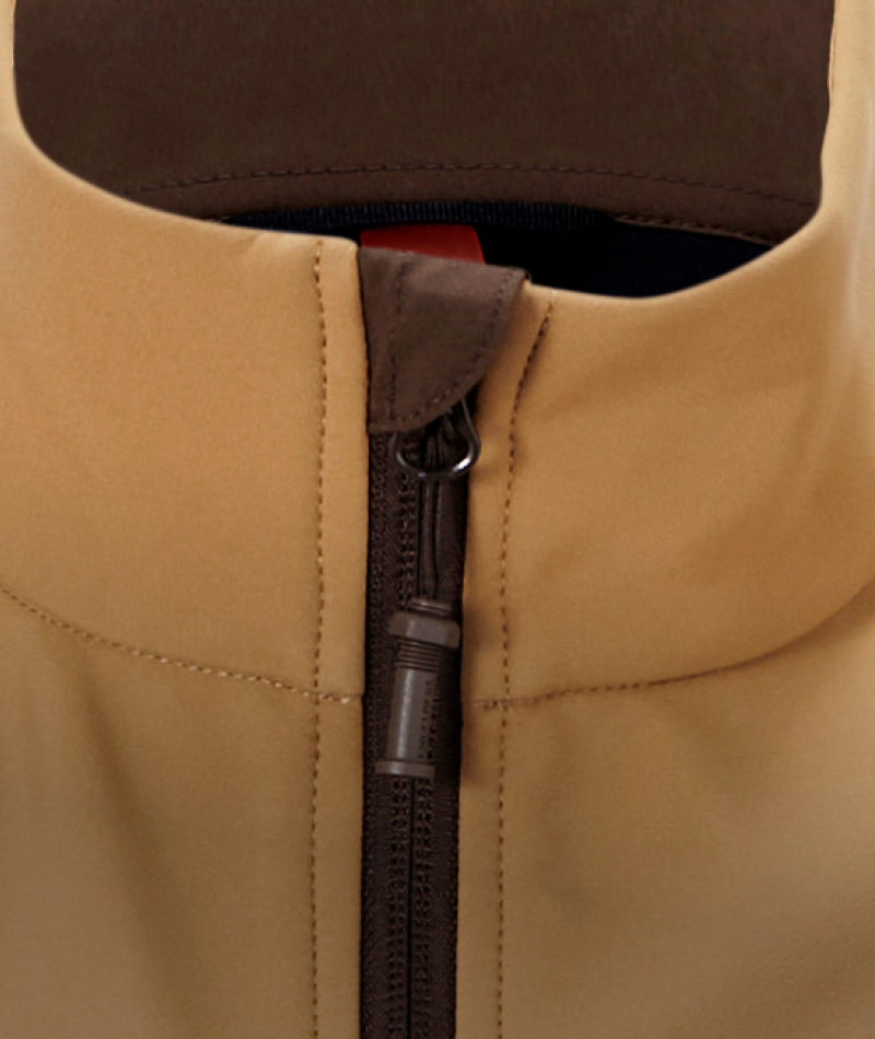 Close-up of a tan softshell jacket with a dark brown zipper and matching brown trim at the collar.