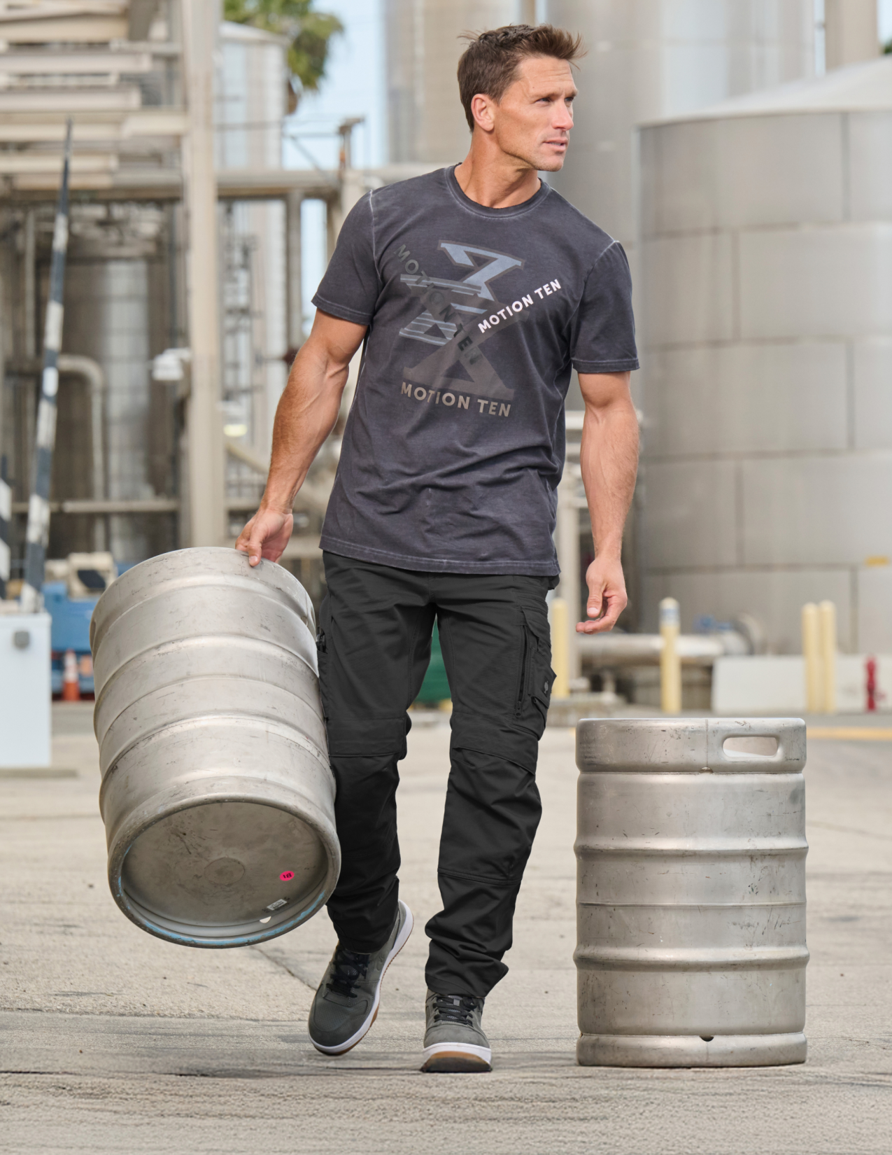 Man carrying a keg in an industrial setting