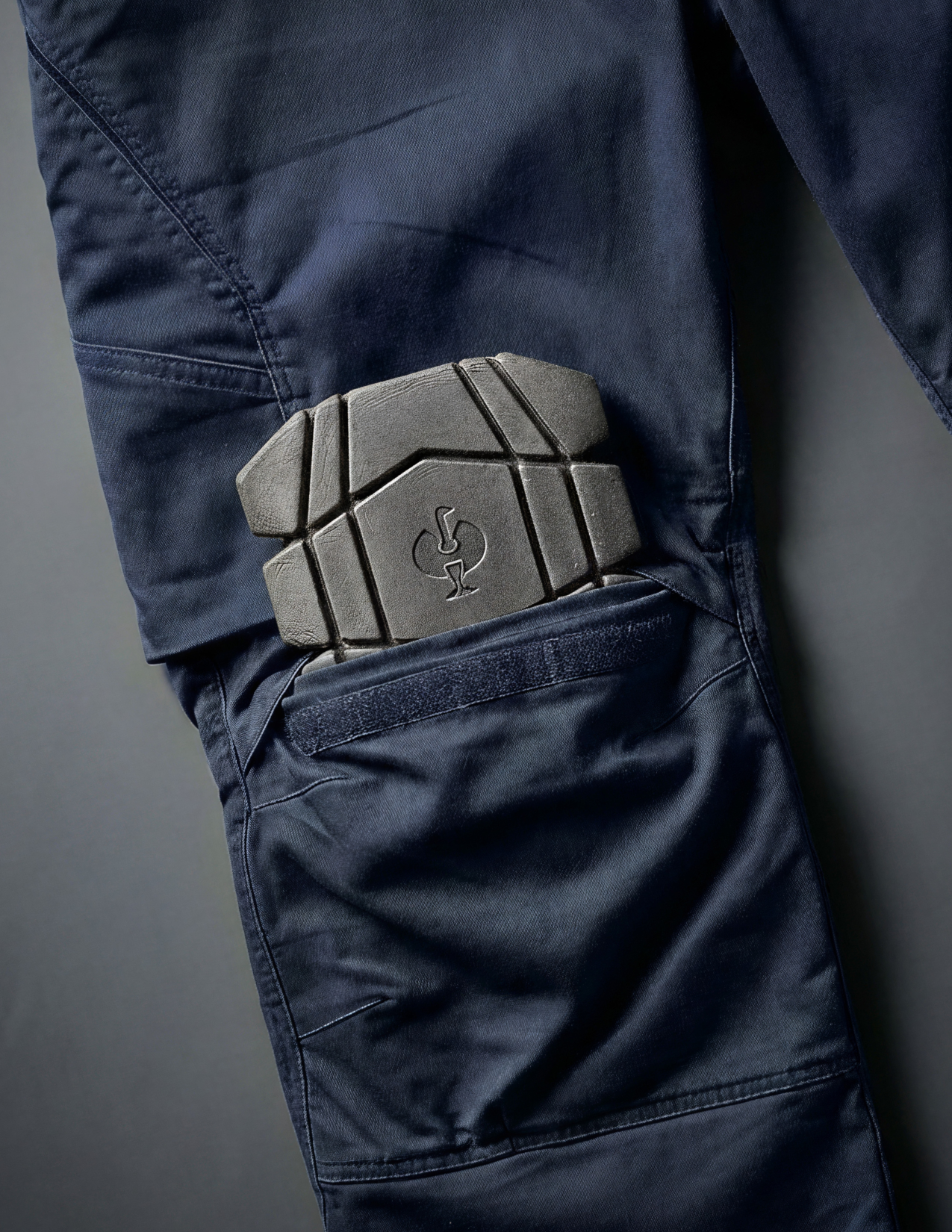 close-up of blue cargo pants with a knee pad slid into the knee pad pocket