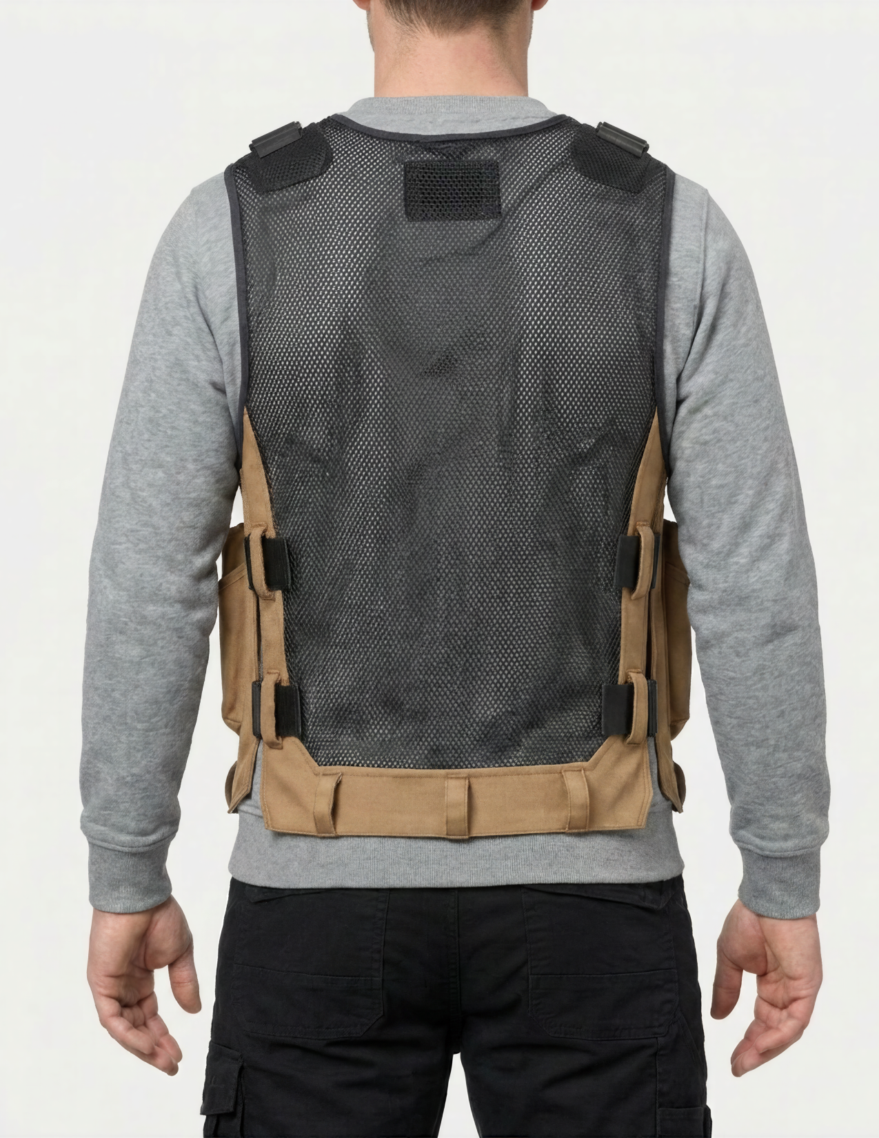 Person wearing a tool vest with a gray shirt and black pants on a white background