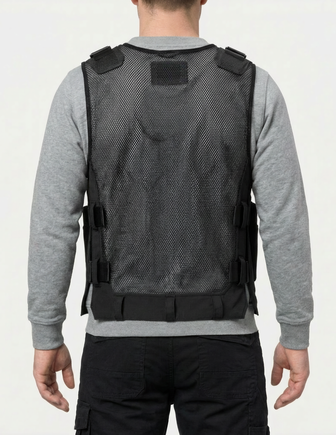 Person wearing a black tool vest on a white background
