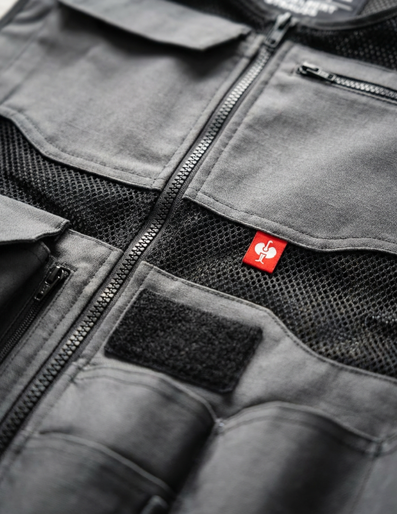 Close-up of a gray vest with a red patch on a black background